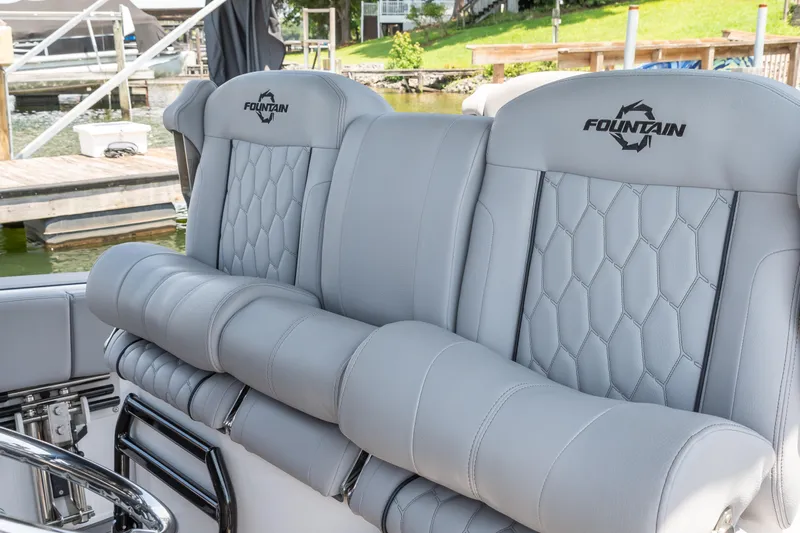  Yacht Photos Pics 2023 Fountain 38 SC boat seats with gray upholstery and logo, docked by a lakeside.