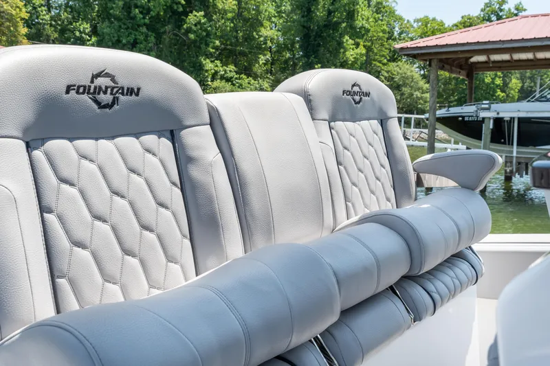  Yacht Photos Pics 2023 Fountain 38 SC boat seats with quilted design, docked near a wooden pier.