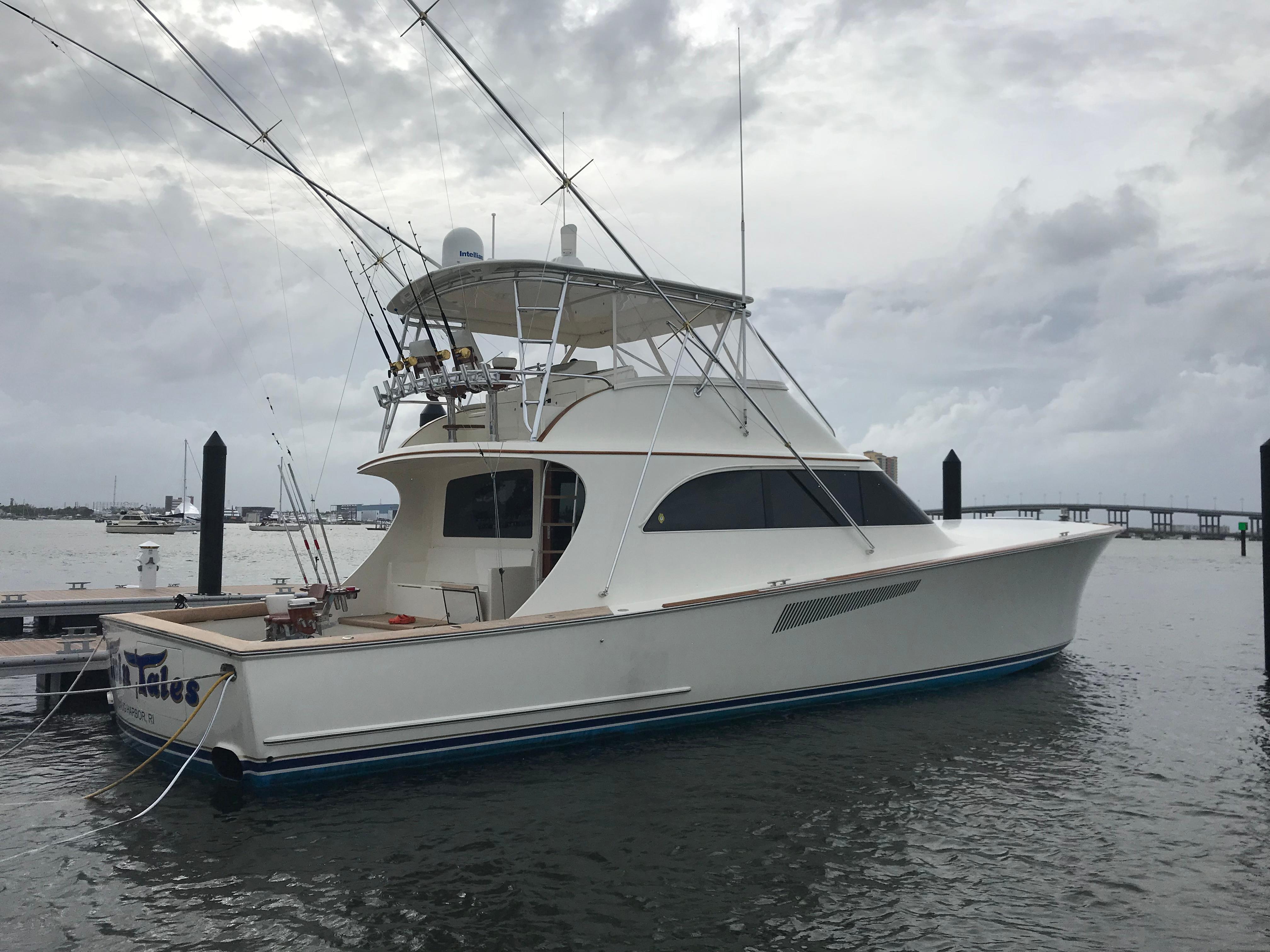 1999 Hines-Farley SPORTFISHERMAN yacht docked in a marina under cloudy skies.