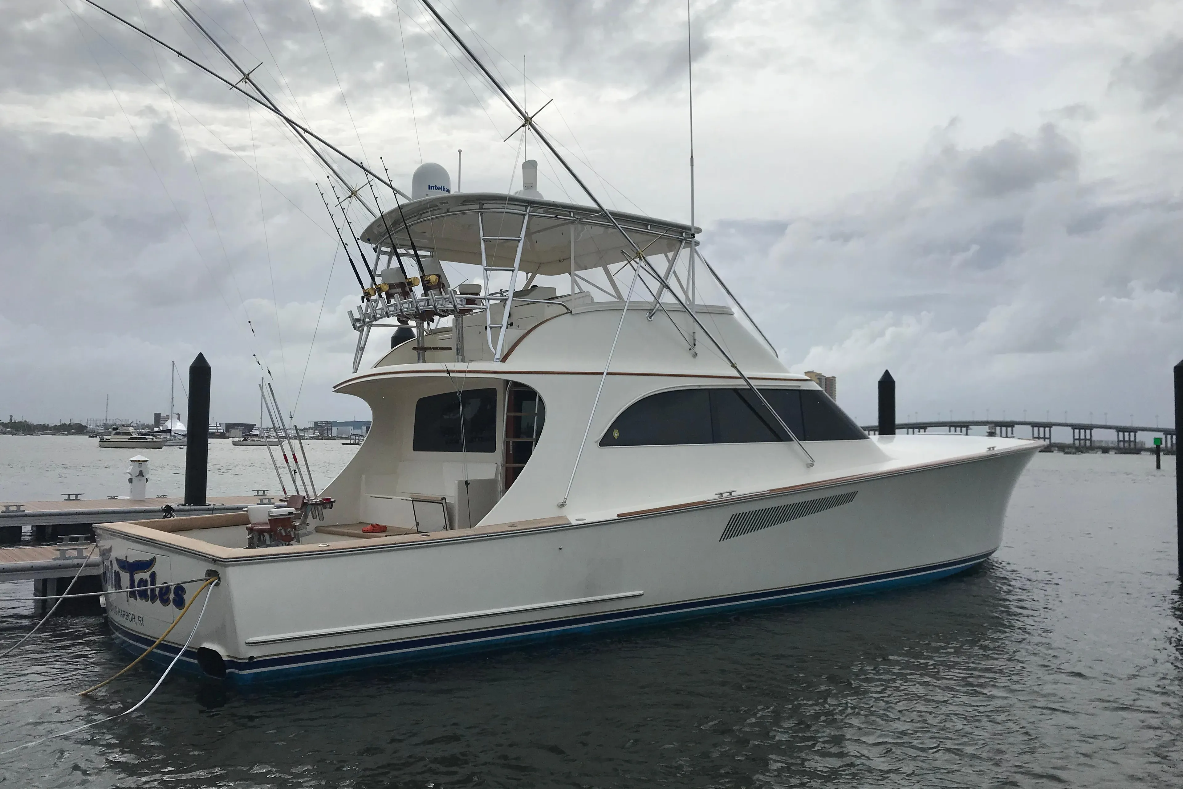 1999 Hines-Farley SPORTFISHERMAN yacht docked in a marina under cloudy skies.