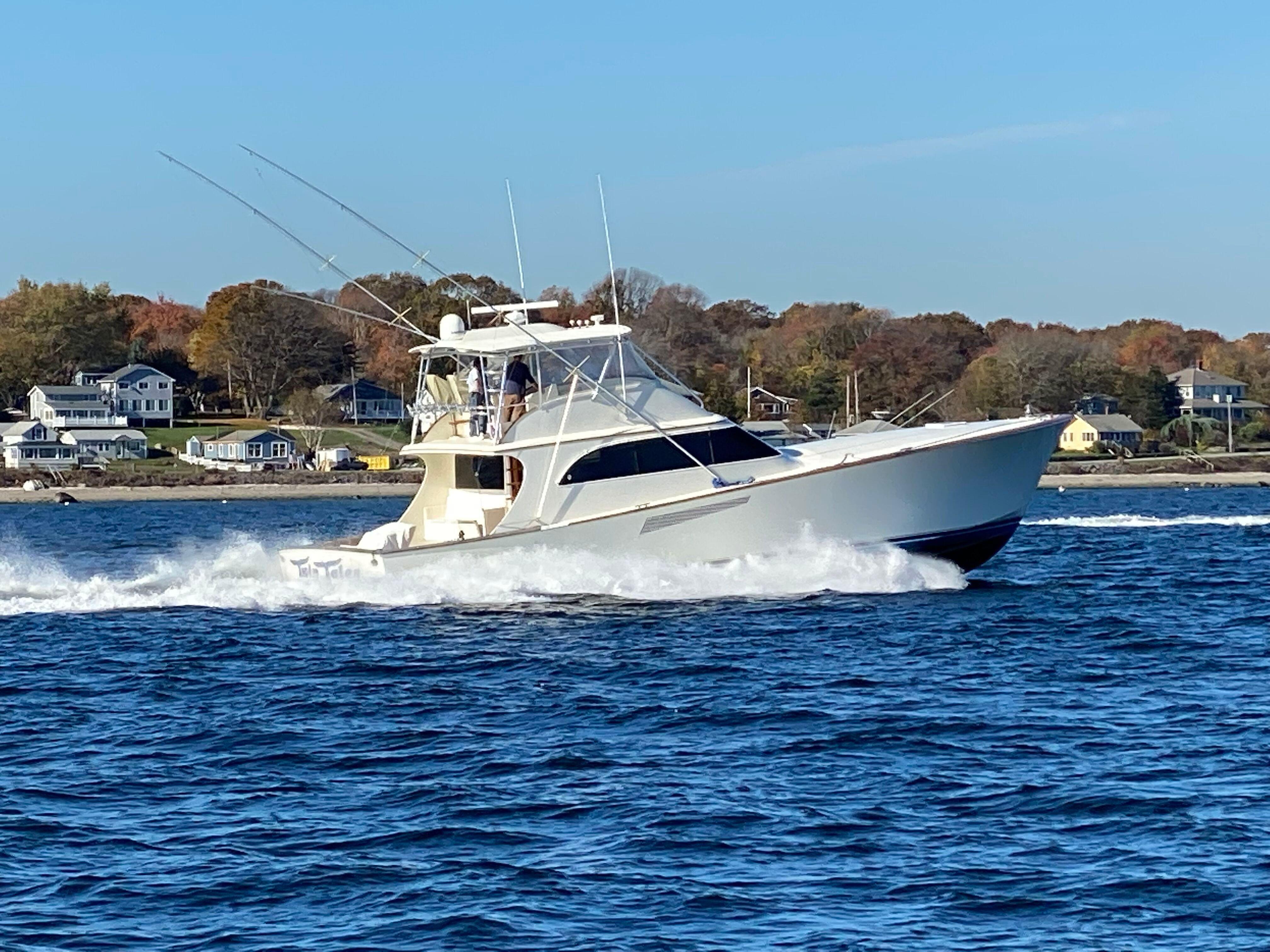 1999 Hines-Farley SPORTFISHERMAN cruising on water near coastal homes.