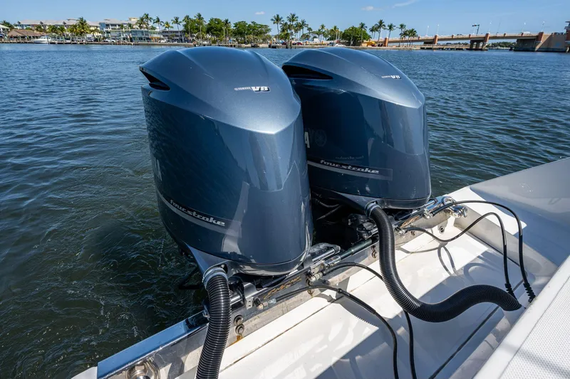  Yacht Photos Pics Twin outboard engines on a 2013 Jupiter 34 boat, docked by a scenic waterfront.