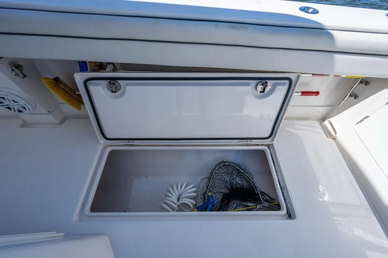  Yacht Photos Pics Open storage compartment on 2013 Jupiter 34 boat with fishing net and coiled rope.