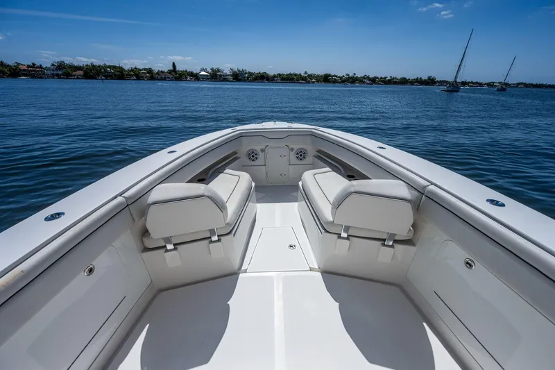  Yacht Photos Pics Bow view of 2013 Jupiter 34 boat on calm water, featuring cushioned seating.