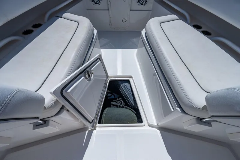  Yacht Photos Pics Interior of a 2013 Jupiter 34 boat showing open storage compartment between cushioned seats.