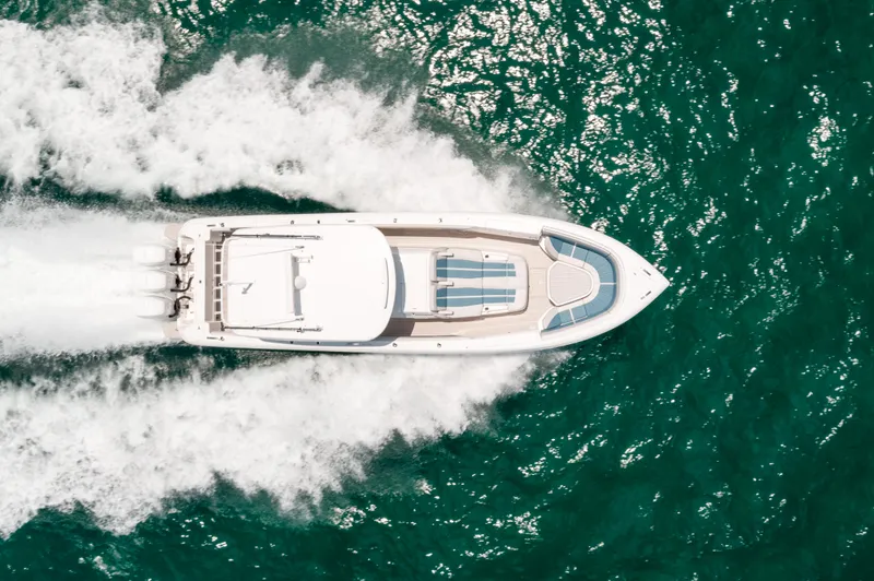  Yacht Photos Pics Aerial view of 2021 Intrepid 407 Nomad SE boat cruising on turquoise water.