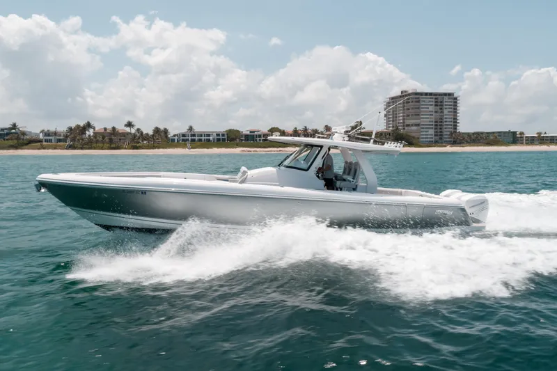  Yacht Photos Pics 2021 Intrepid 407 Nomad SE boat cruising on ocean near beachfront buildings.