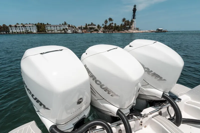  Yacht Photos Pics Triple Mercury engines on a 2021 Intrepid 407 Nomad SE, with a lighthouse in the background.