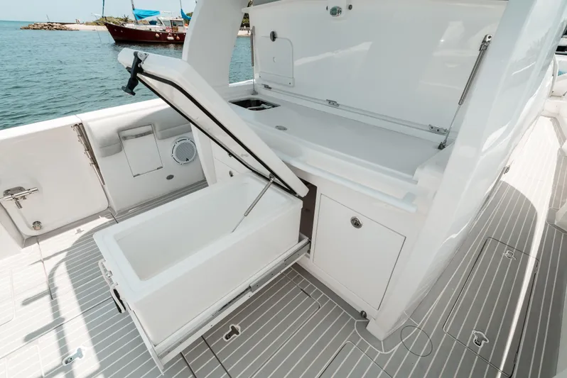  Yacht Photos Pics 2021 Intrepid 407 Nomad SE boat with open storage compartments on deck.