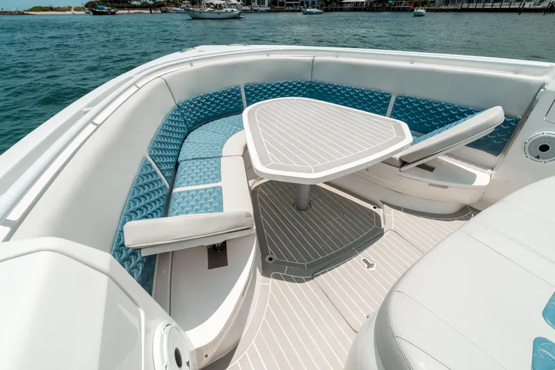  Yacht Photos Pics 2021 Intrepid 407 Nomad SE boat interior with blue seating and table on the water.