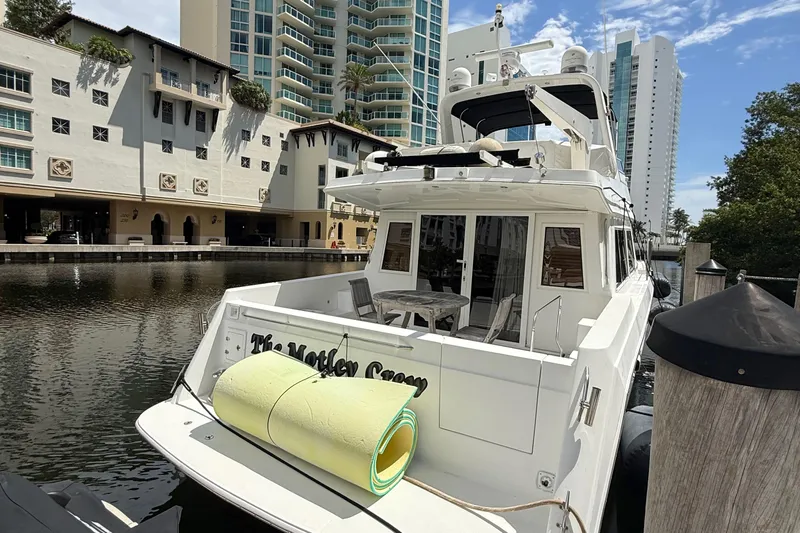 The Motley Crew Yacht Photos Pics Luxury yacht "The Motley Crew" docked near waterfront buildings, Rival 5700 Navigator, 2003 model.