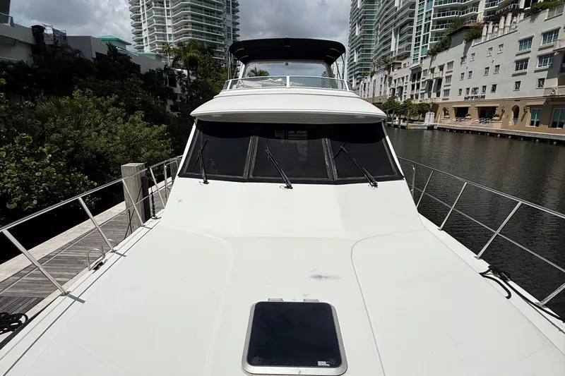 The Motley Crew Yacht Photos Pics 2003 Rival 5700 Navigator yacht docked near modern waterfront buildings.