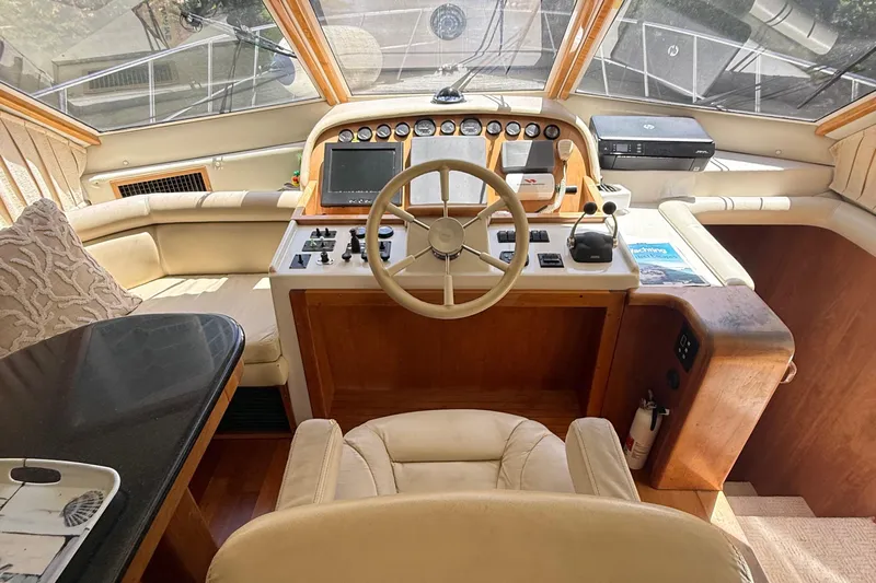 The Motley Crew Yacht Photos Pics Luxurious 2003 Rival 5700 Navigator yacht cockpit with steering wheel and control panel.