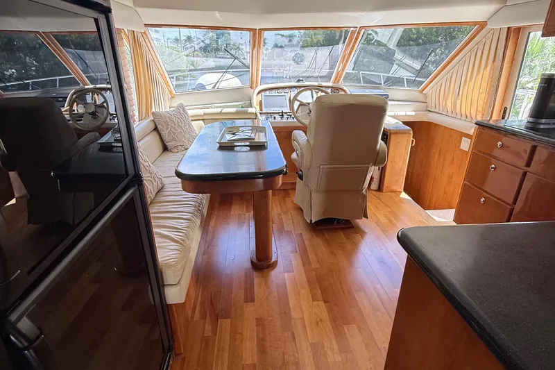 The Motley Crew Yacht Photos Pics Luxurious interior of 2003 Rival 5700 Navigator yacht with wood flooring and plush seating.