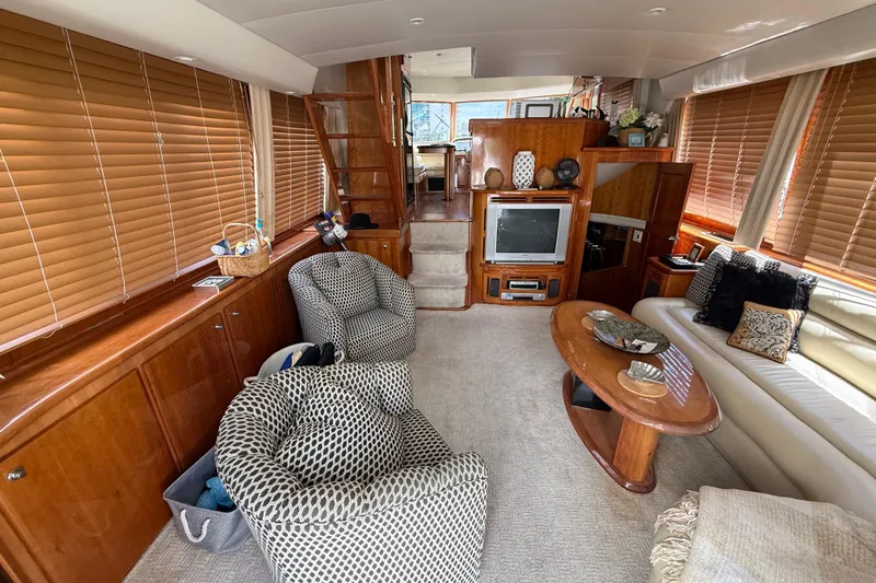 The Motley Crew Yacht Photos Pics Luxurious interior of 2003 Rival 5700 Navigator yacht with cozy seating and elegant decor.