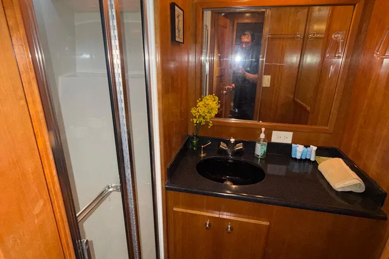 The Motley Crew Yacht Photos Pics Luxurious bathroom in 2003 Rival 5700 Navigator yacht with wooden accents and modern amenities.