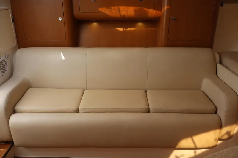 Good Karma Yacht Photos Pics Luxurious beige sofa in 2006 Intrepid 377 Walk Around cabin interior.