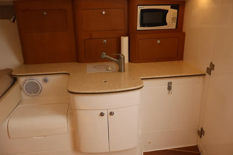 Good Karma Yacht Photos Pics 2006 Intrepid 377 Walk Around boat interior with kitchenette, featuring cabinets, sink, and microwave.