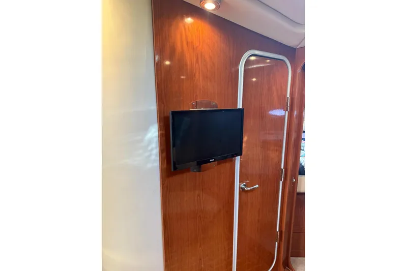 Borabora III Yacht Photos Pics Interior of 2007 Regal Commodore 3760 IB with mounted TV and wooden door.