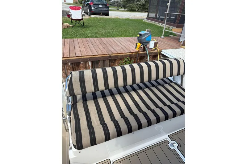 Borabora III Yacht Photos Pics Striped seating on 2007 Regal Commodore 3760 IB boat, docked near wooden deck.