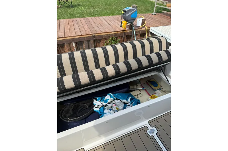 Borabora III Yacht Photos Pics 2007 Regal Commodore 3760 IB boat storage compartment with striped cushion and various items.