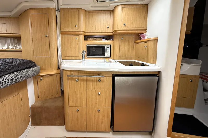  Yacht Photos Pics 2013 Four Winns Vista 375 interior kitchen with wood cabinets, microwave, and mini fridge.