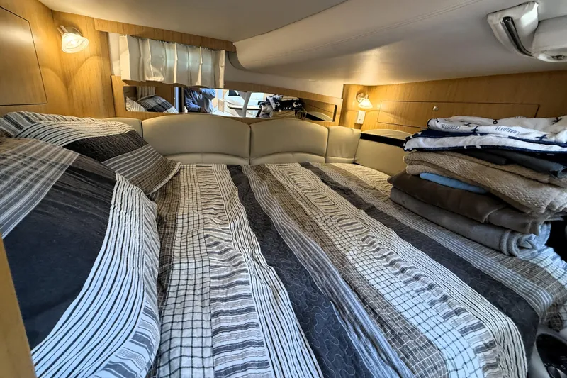  Yacht Photos Pics 2013 Four Winns Vista 375 cabin interior with striped bedding and folded towels.