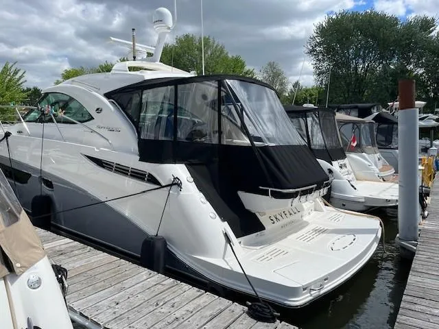  Yacht Photos Pics 2014 Sea Ray 410 Sundancer yacht docked at marina, featuring sleek design and covered cockpit.