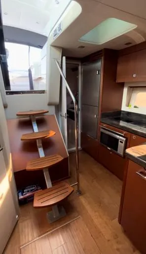  Yacht Photos Pics Interior of 2014 Sea Ray 410 Sundancer yacht with modern kitchen and wooden stairs.