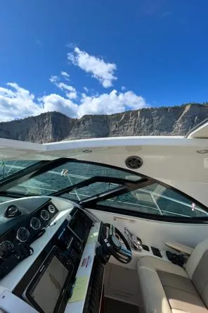  Yacht Photos Pics 2014 Sea Ray 410 Sundancer yacht cruising near rocky cliffs under a clear blue sky.