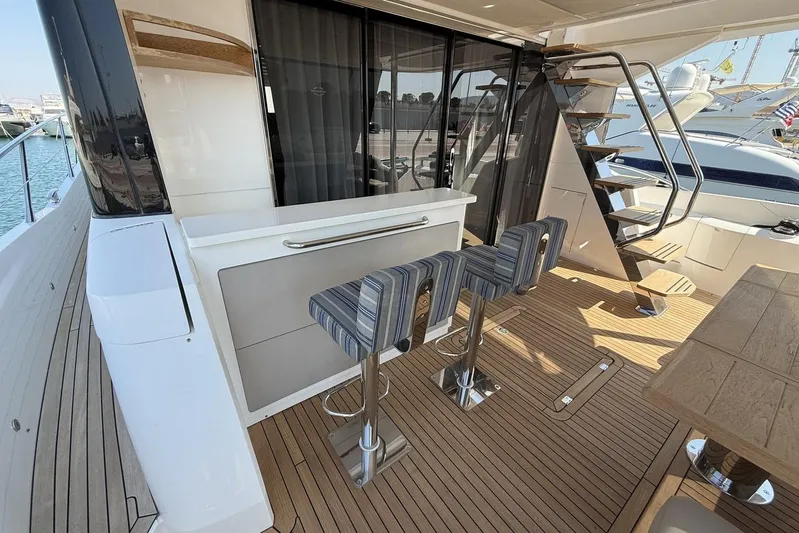 M/y Bishwish Yacht Photos Pics Luxurious 2018 Sunseeker Manhattan 66 yacht deck with bar stools and staircase.