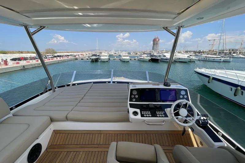 M/y Bishwish Yacht Photos Pics Luxurious 2018 Sunseeker Manhattan 66 yacht helm with marina view and modern controls.