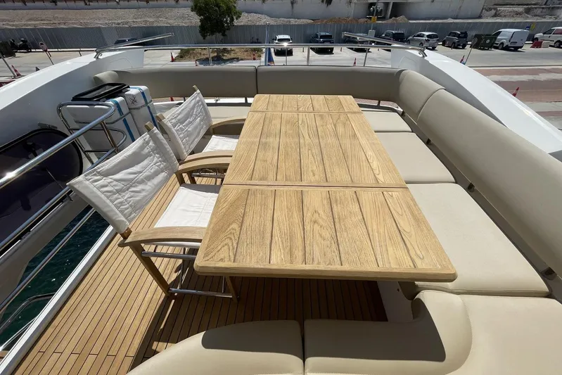M/y Bishwish Yacht Photos Pics Luxurious Sunseeker Manhattan 66 yacht deck with wooden table and cushioned seating, 2018 model.