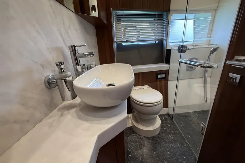 M/y Bishwish Yacht Photos Pics Luxurious bathroom in 2018 Sunseeker Manhattan 66 yacht with modern fixtures and marble accents.