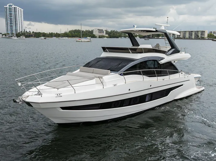 Harbour Time Yacht Photos Pics Luxury 2021 Astondoa 52 yacht cruising on a calm waterway under cloudy skies.