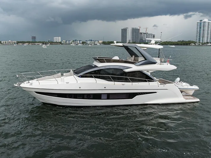 Harbour Time Yacht Photos Pics 2021 Astondoa 52 yacht cruising on a cloudy day near urban skyline.