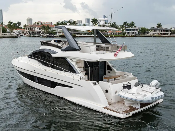 Harbour Time Yacht Photos Pics Luxury 2021 Astondoa 52 yacht cruising on a scenic waterfront.