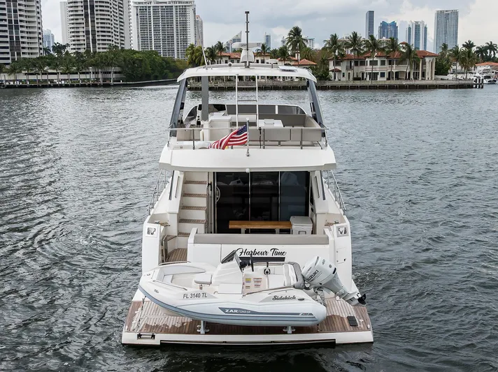 Harbour Time Yacht Photos Pics Astondoa 52 yacht, 2021 model, docked with a small boat, city skyline in background.