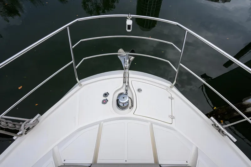 Harbour Time Yacht Photos Pics Bow of 2021 Astondoa 52 yacht with anchor and railing, reflecting on water.