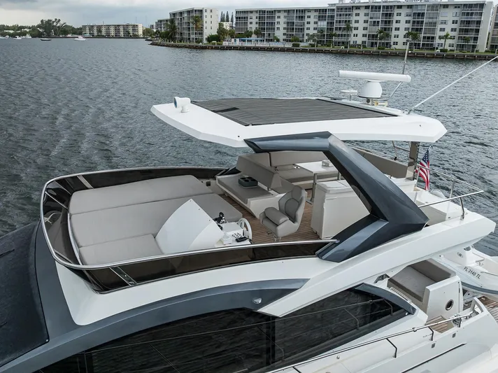 Harbour Time Yacht Photos Pics Luxurious 2021 Astondoa 52 yacht with spacious deck, cruising near waterfront apartments.