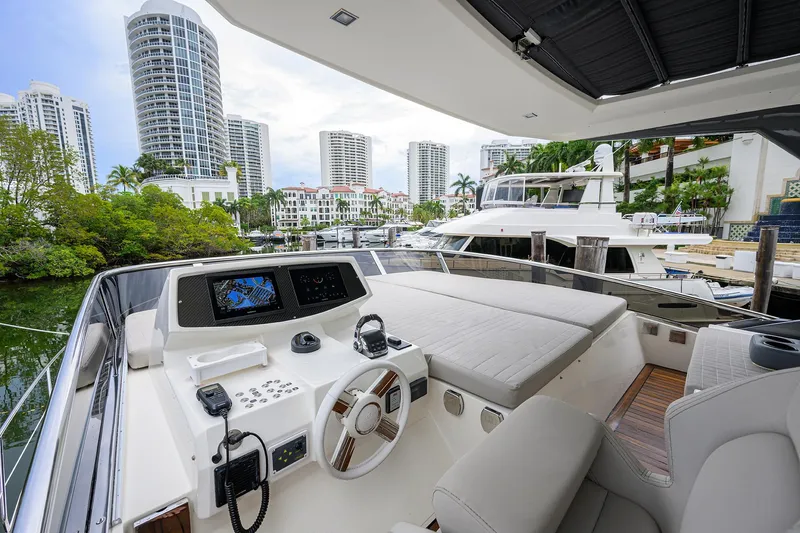 Harbour Time Yacht Photos Pics Astondoa 52 yacht helm with city skyline, 2021 model, luxurious marina setting.
