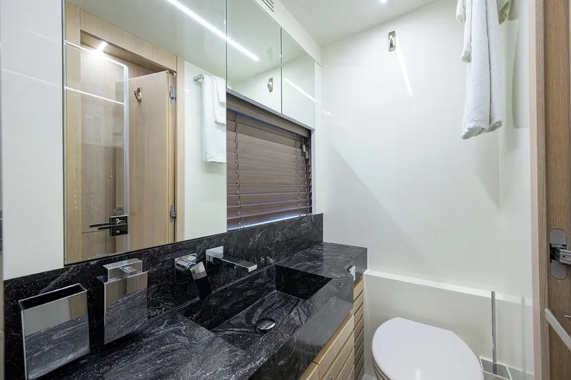 Harbour Time Yacht Photos Pics Luxurious bathroom in 2021 Astondoa 52 yacht with sleek black countertop.