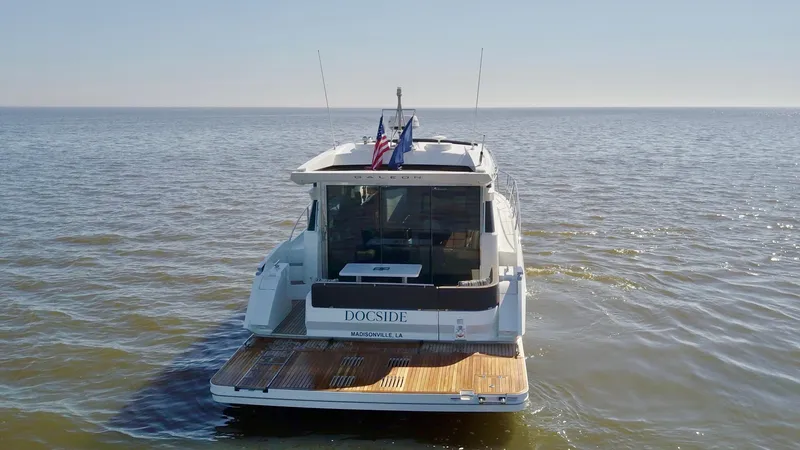 Docside Yacht Photos Pics 2021 Galeon 430 HTC yacht on open water, rear view with flags displayed.