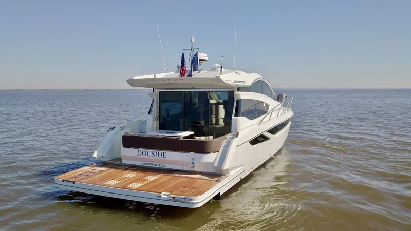 Docside Yacht Photos Pics 2021 Galeon 430 HTC yacht on calm water, rear view with open deck.