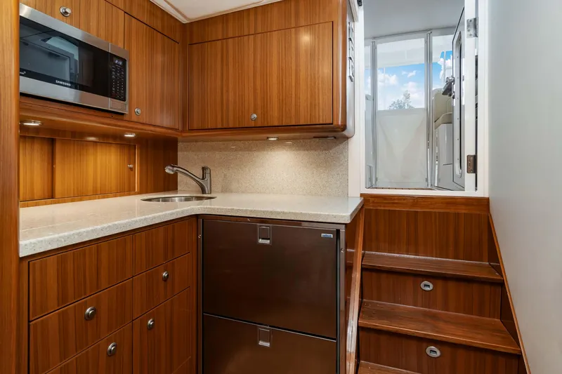 Fin Planner II Yacht Photos Pics Luxurious 2021 Viking 38 Billfish yacht interior with modern kitchenette and wooden cabinetry.