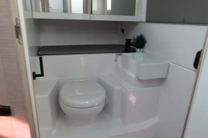  Yacht Photos Pics 2024 Axopar 45 XC Cross Cabin BRABUS Trim bathroom interior with toilet and sink.