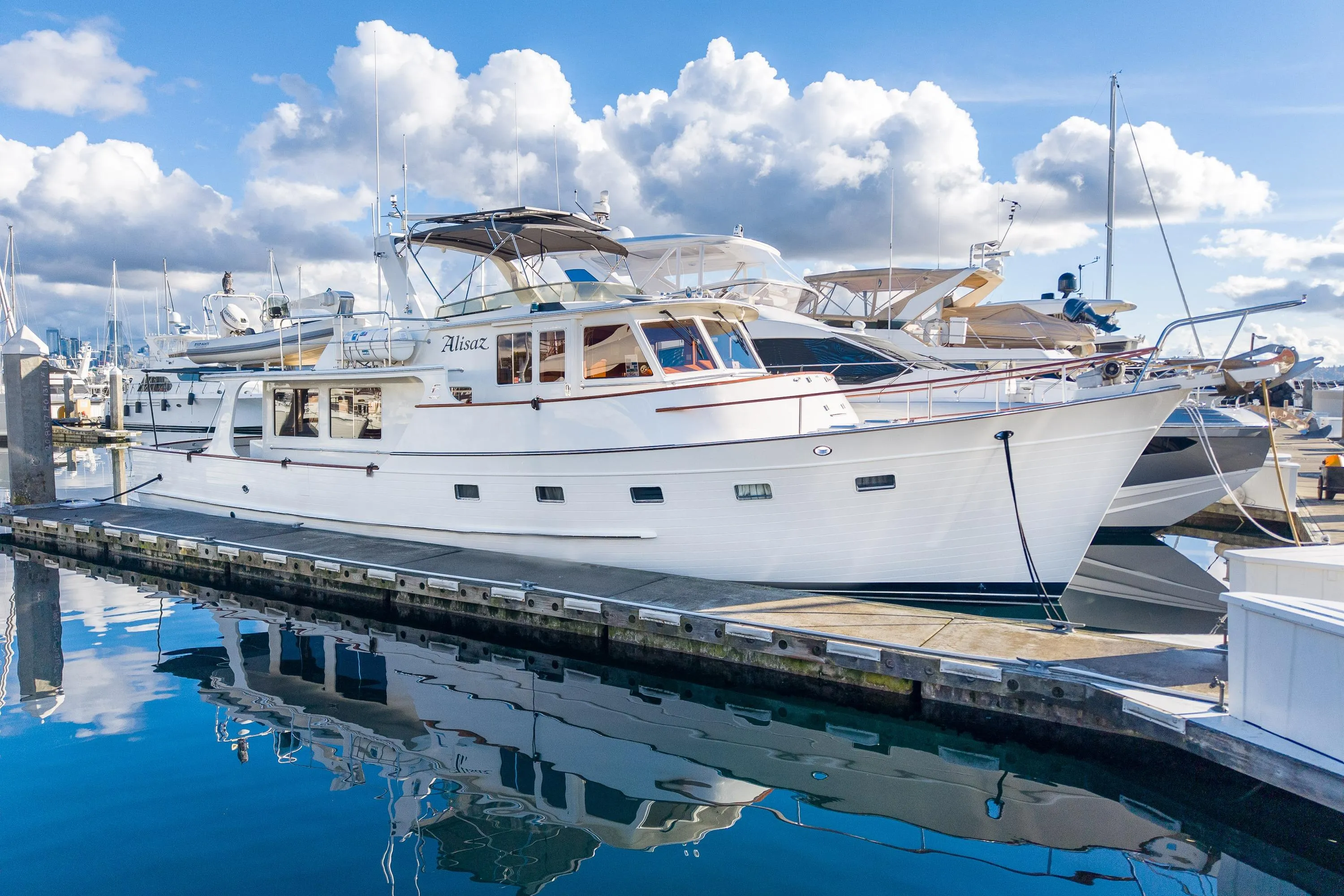 2001 Fleming 55 Pilothouse yacht docked at marina under blue sky.