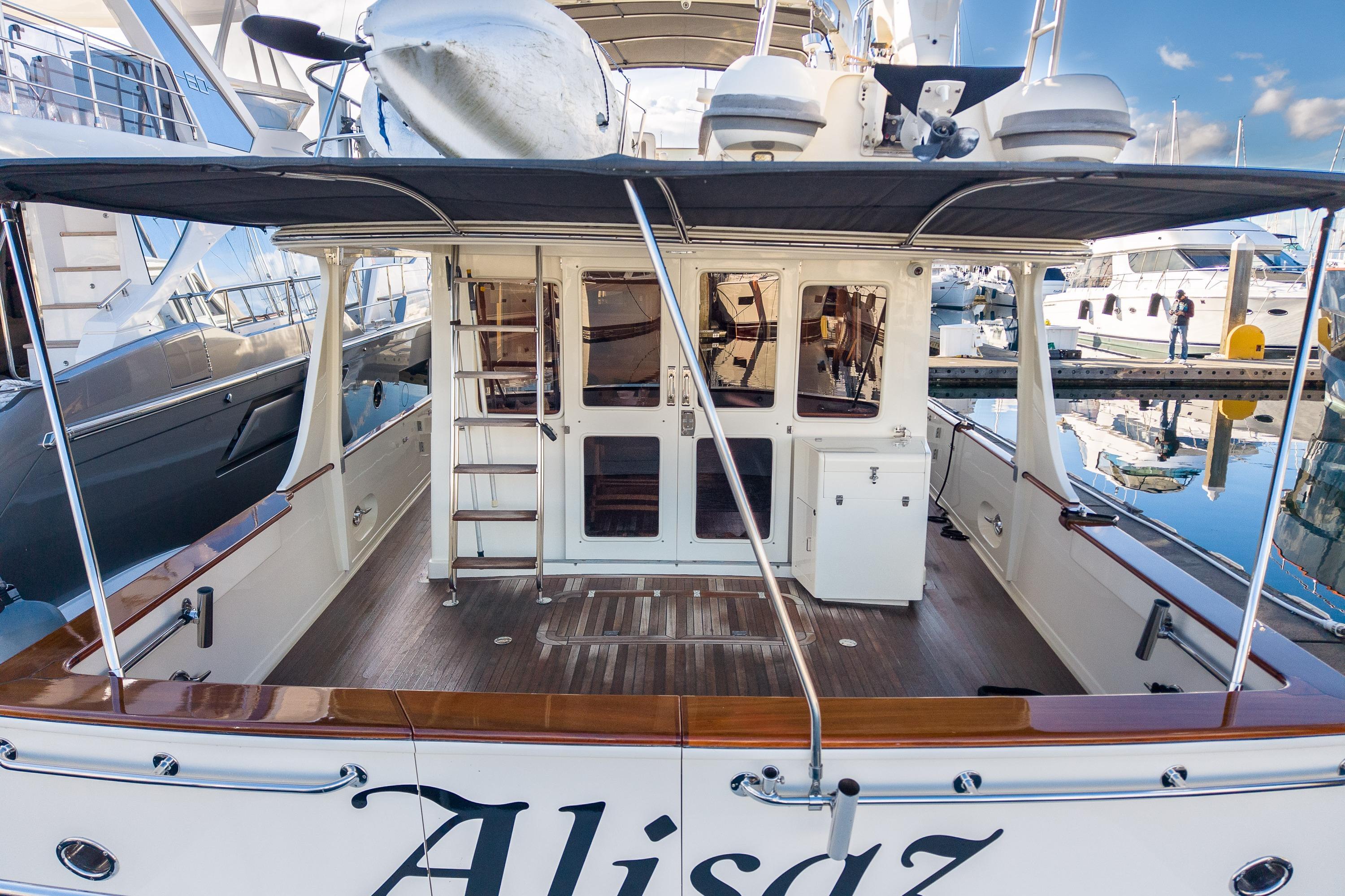 2001 Fleming 55 Pilothouse yacht at marina, featuring spacious deck and elegant design.