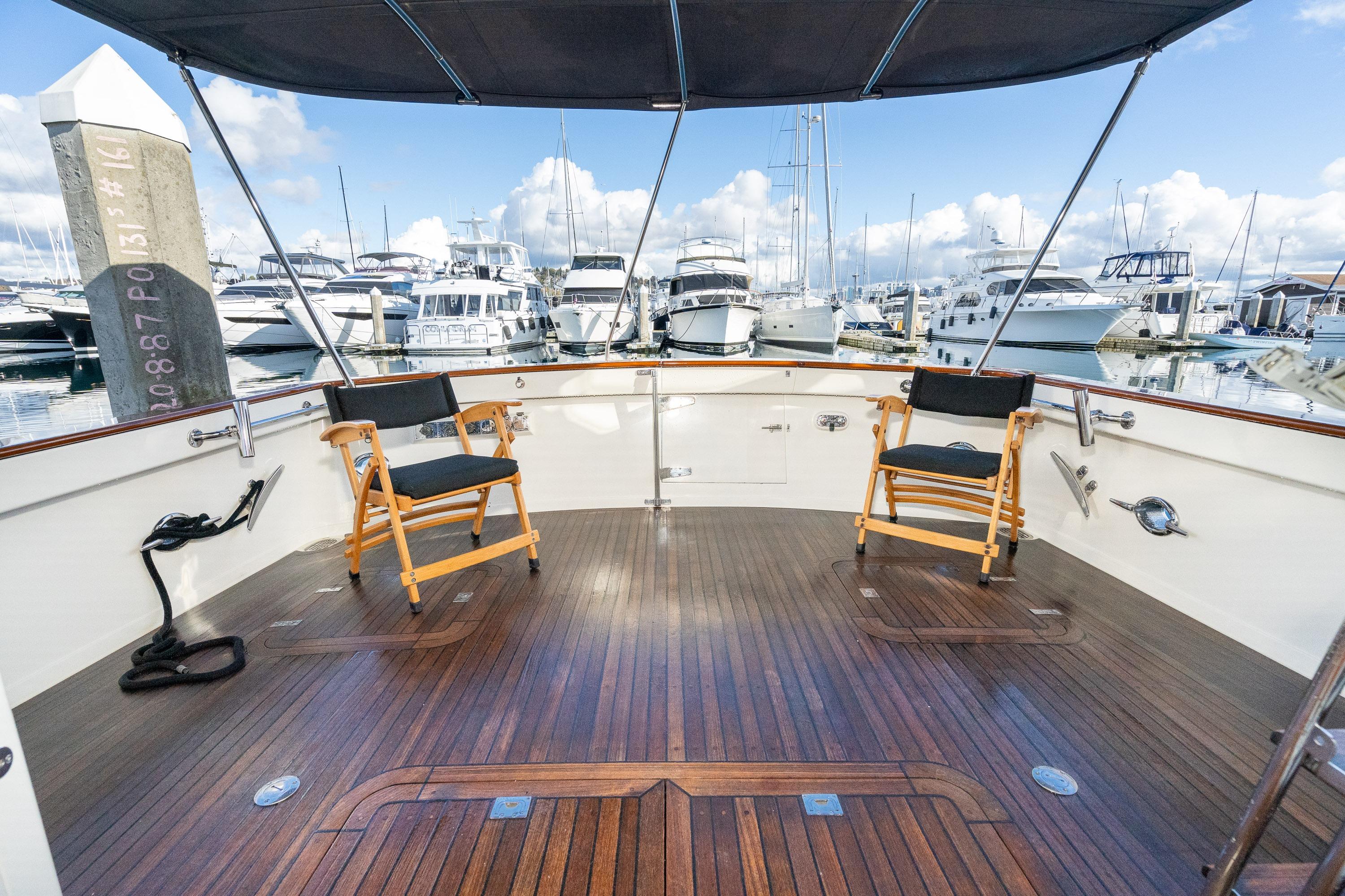 Spacious deck of 2001 Fleming 55 Pilothouse yacht with marina view.