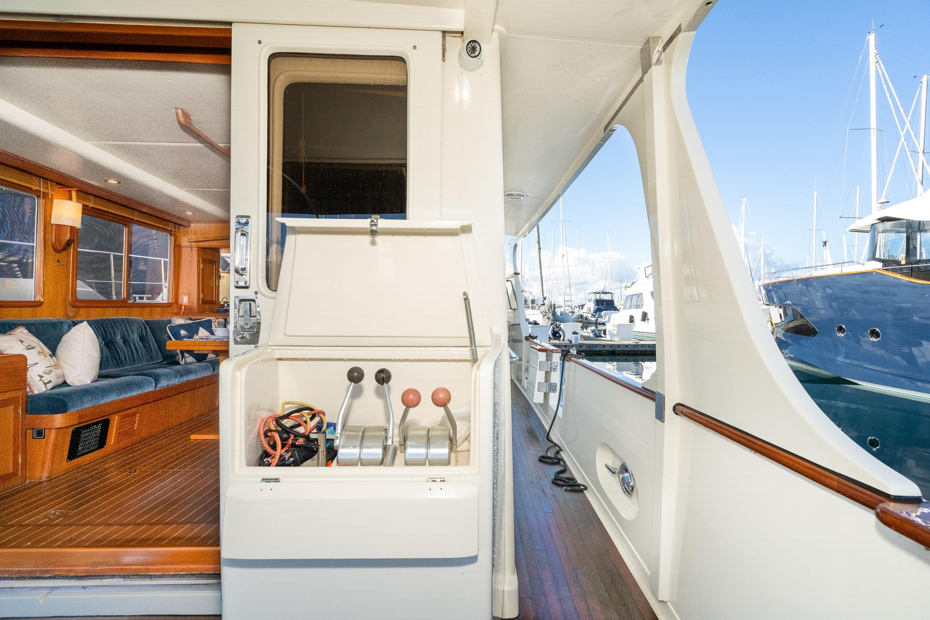 2001 Fleming 55 Pilothouse yacht interior and deck, showcasing luxurious seating and marina view.